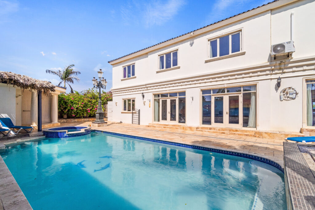 Inviting pool area at La Casa Piu Bella with tropical landscaping.